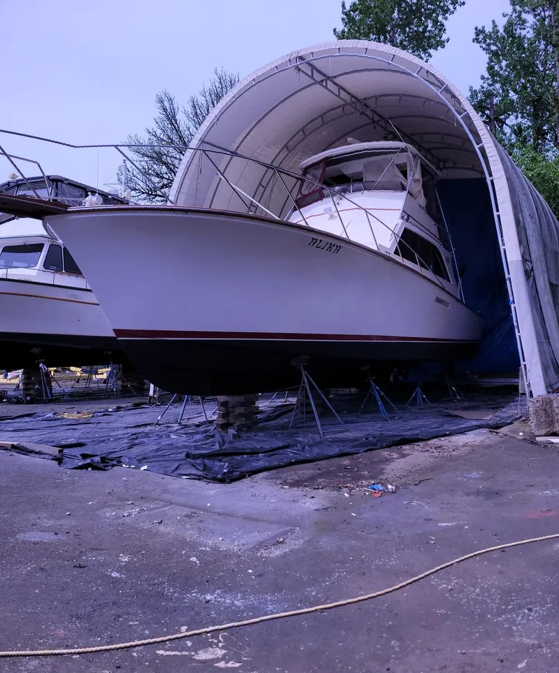 Slide: The Image of 1983 Ocean Yachts Super Sport boat in dry dock under a protective canopy. - 28