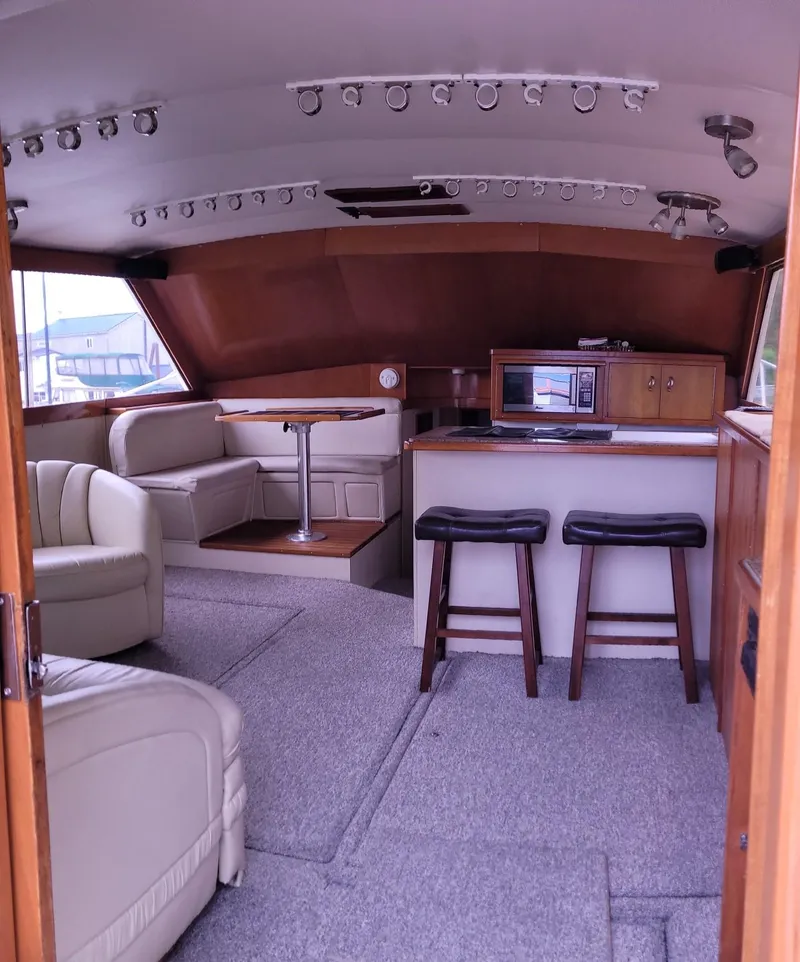 Slide: The Image of Interior of 1983 Ocean Yachts Super Sport with seating, bar stools, and kitchenette. - 4
