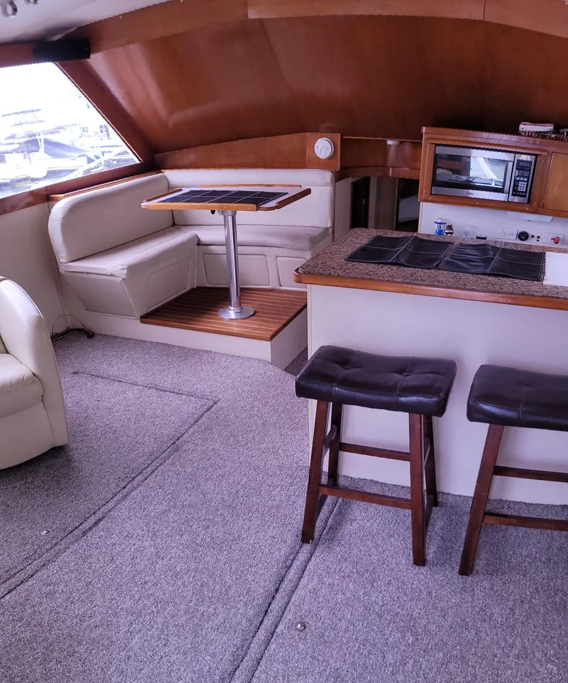 Slide: The Image of Interior of 1983 Ocean Yachts Super Sport with seating, table, and kitchenette. - 7