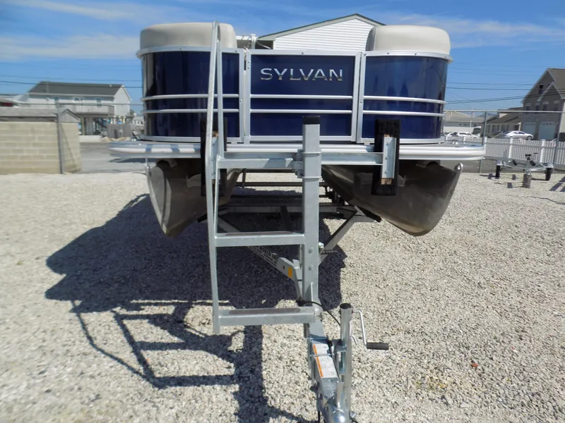 Slide: The Image of 2022 Sylvan Mirage Fish 8522 Party Fish pontoon boat on trailer, parked on gravel. - 14