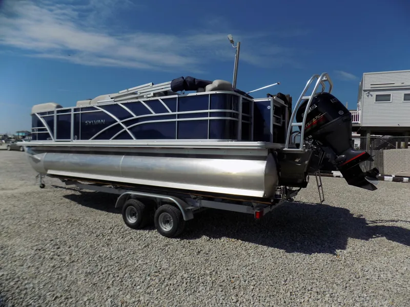 Slide: The Image of 2022 Sylvan Mirage Fish 8522 Party Fish pontoon boat on trailer, parked on gravel. - 3