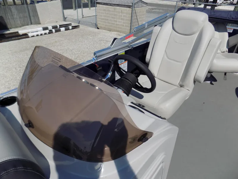Slide: The Image of 2022 Sylvan Mirage Fish 8522 Party Fish boat helm with beige seat and tinted windshield. - 8