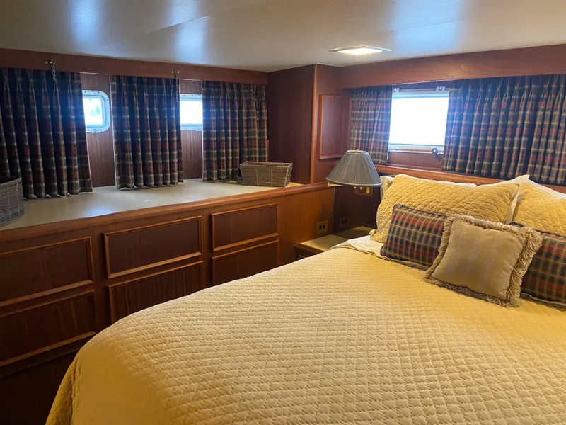 Slide: The Image of 1983 Hatteras 53 Motor Yacht bedroom with cozy bedding and plaid curtains. - 19