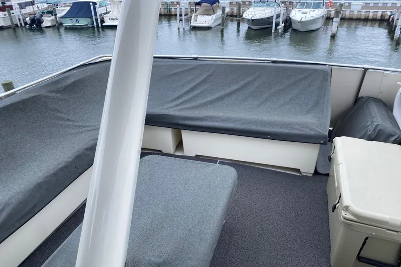 Slide: The Image of 1983 Hatteras 53 Motor Yacht deck with gray seating, docked at marina. - 29