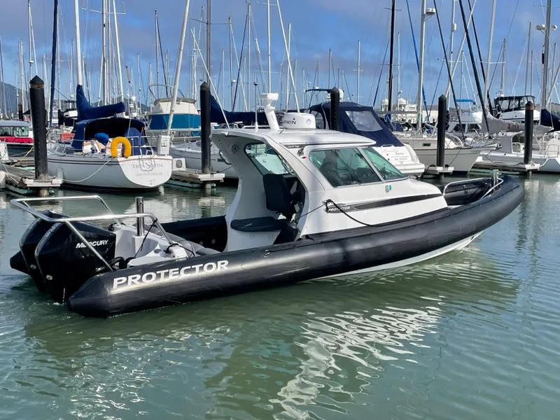 Slide: The Image of 2018 Protector Targa 30 boat docked in a marina, surrounded by sailboats. - 0