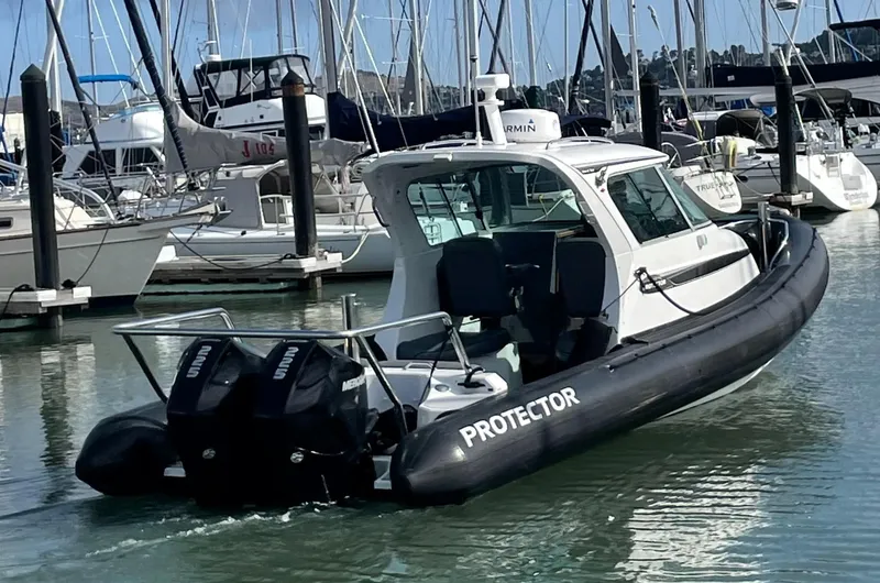 Slide: The Image of 2018 Protector Targa 30 boat docked in marina with twin engines. - 1