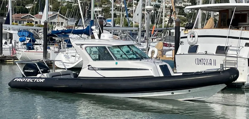 Slide: The Image of 2018 Protector Targa 30 boat docked in a marina, surrounded by other vessels. - 2