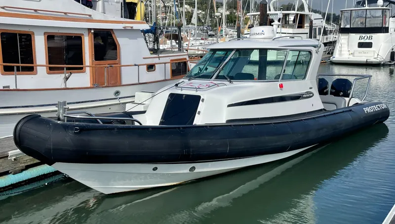 Slide: The Image of 2018 Protector Targa 30 boat docked in marina, featuring sleek design and black rubber fender. - 3