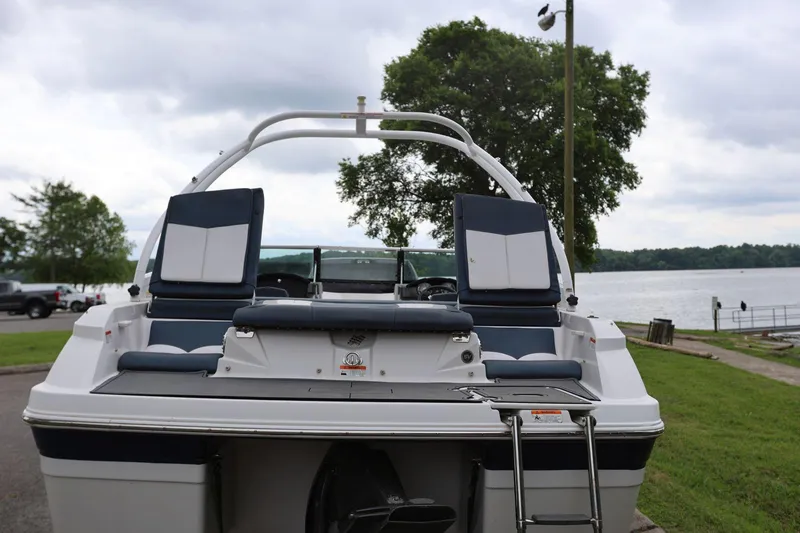 Slide: The Image of 2015 Four Winns H200 boat with seating, parked near a scenic lake. - 12