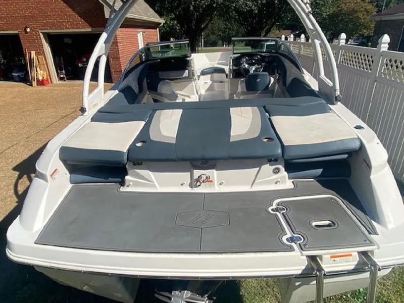 Slide: The Image of 2015 Four Winns H200 boat with spacious seating and sleek design in a driveway setting. - 14