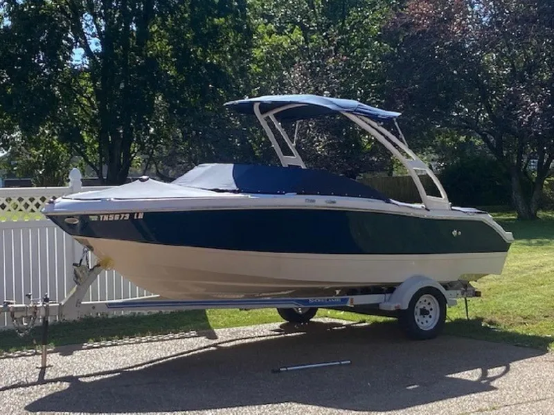 Slide: The Image of 2015 Four Winns H200 boat on a trailer in a driveway. - 15