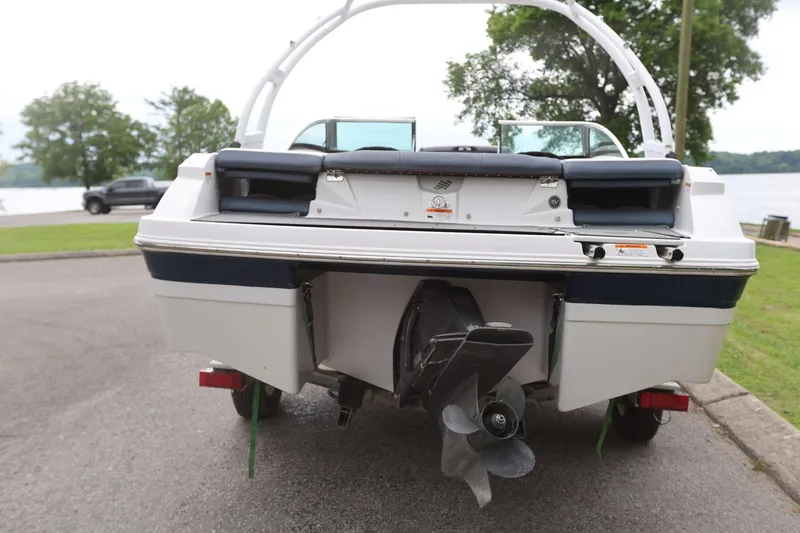 Slide: The Image of 2015 Four Winns H200 boat rear view with propeller, parked near a lake. - 4