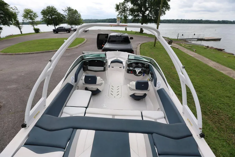 Slide: The Image of 2015 Four Winns H200 boat interior with seating, steering wheel, and lake view. - 6