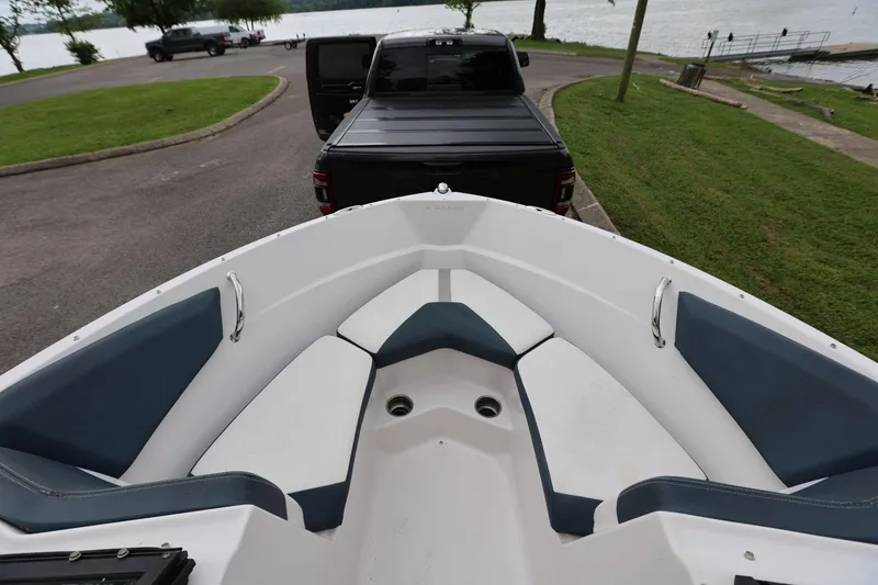 Slide: The Image of Bow seating area of a 2015 Four Winns H200 boat, parked near a lake. - 8