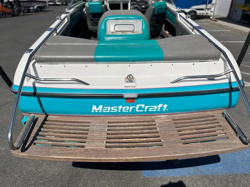 Slide: The Image of 1991 MasterCraft Maristar 210 boat with teal and gray seating, rear view. - 10