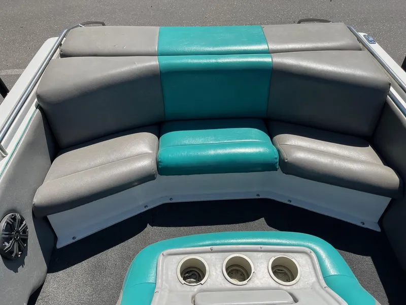 Slide: The Image of 1991 MasterCraft Maristar210 boat interior with teal and gray seating and cup holders. - 14