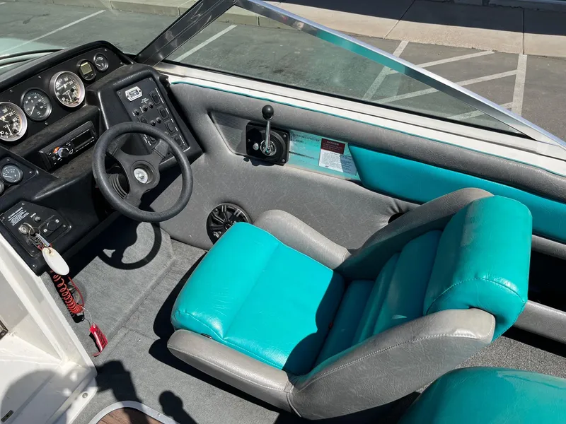 Slide: The Image of 1991 MasterCraft Maristar210 boat interior with teal and gray seating, steering wheel, and dashboard controls. - 21