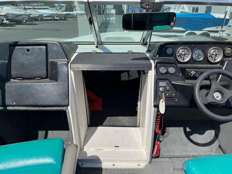 Slide: The Image of 1991 MasterCraft Maristar210 boat dashboard with gauges, steering wheel, and storage compartment. - 28