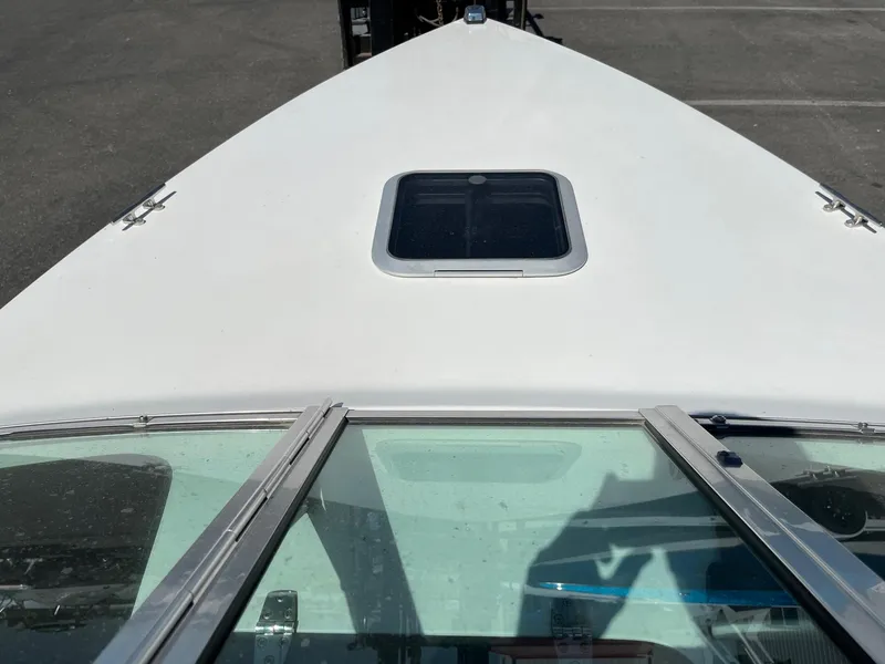 Slide: The Image of 1991 MasterCraft Maristar210 boat deck with windshield and hatch, parked on asphalt. - 31