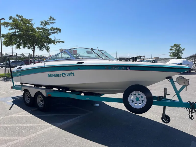 Slide: The Image of 1991 MasterCraft Maristar 210 boat on trailer in parking lot, sunny day. - 6
