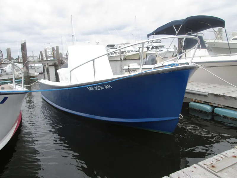 Slide: The Image of 1975 Tripp Center Console boat docked at a marina, featuring a sleek blue hull. - 10
