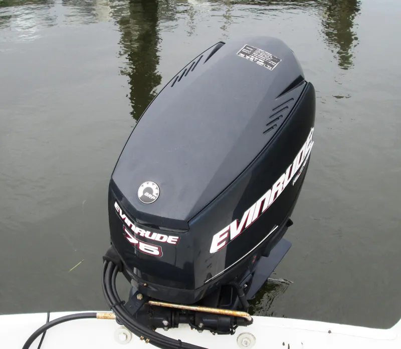 Slide: The Image of Evinrude outboard motor on a 1975 Tripp Center Console boat, docked on calm water. - 3