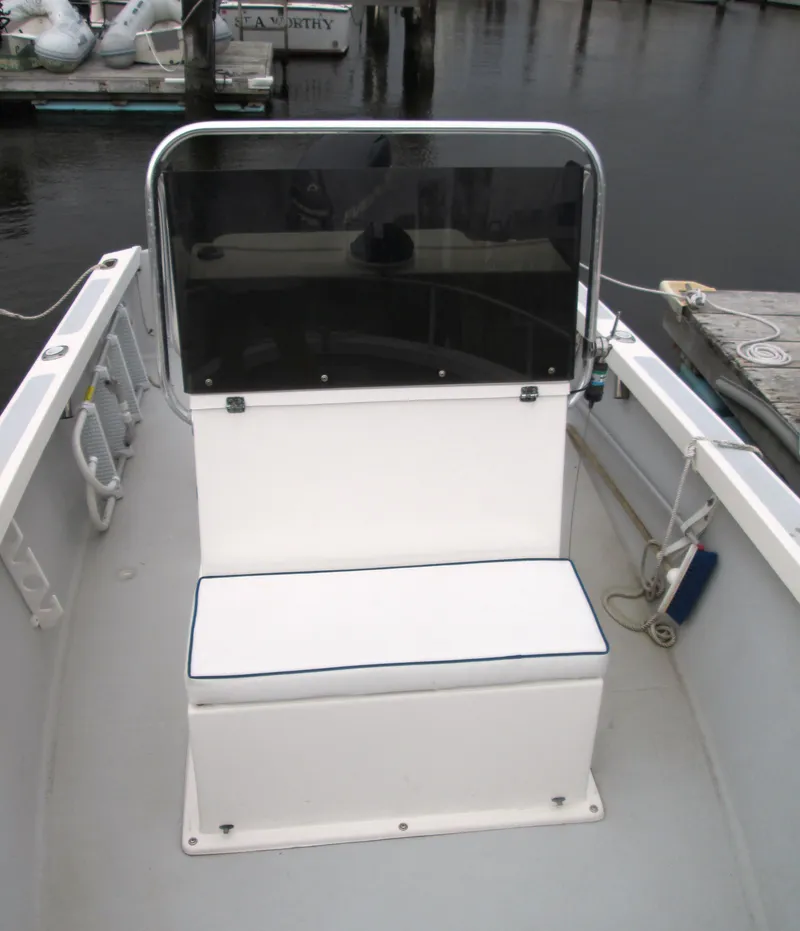 Slide: The Image of 1975 Tripp Center Console boat with seating and windshield, docked at marina. - 5
