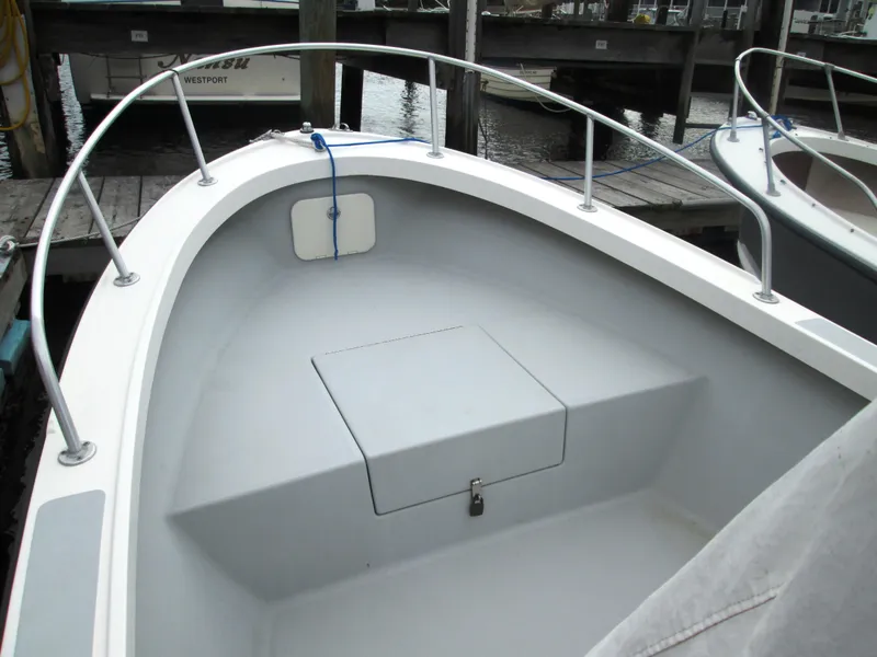 Slide: The Image of 1975 Tripp Center Console boat with clean deck and storage compartment, docked at marina. - 7