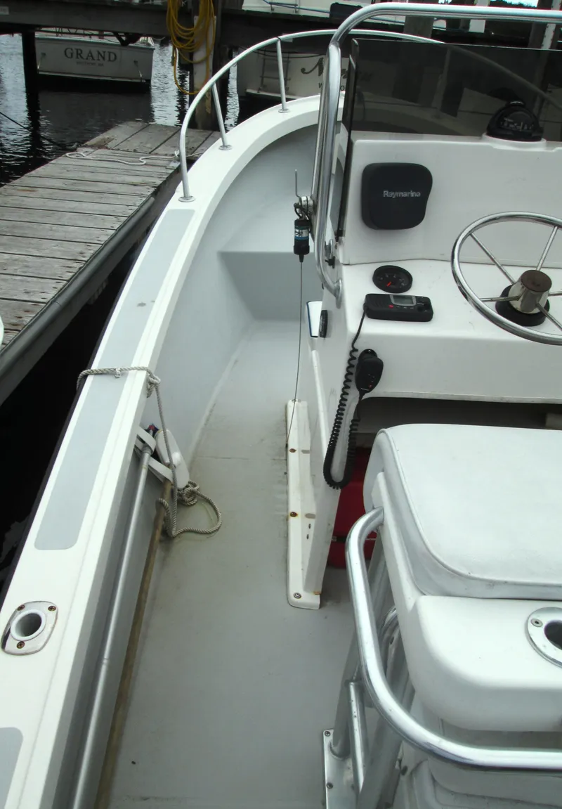 Slide: The Image of 1975 Tripp Center Console boat interior with steering wheel and dock view. - 8