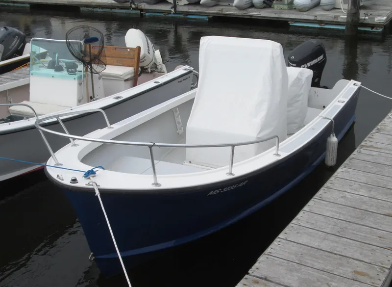 Slide: The Image of 1975 Tripp Center Console boat docked, featuring a blue hull and covered seating area. - 9