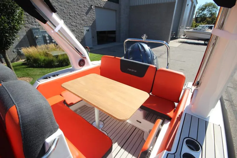Slide: The Image of 2022 Zodiac Medline 7.5 NEO boat interior with orange seating and wooden table. - 1