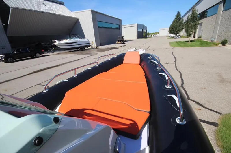Slide: The Image of 2022 Zodiac Medline 7.5 NEO boat with orange seating, docked near industrial buildings. - 23