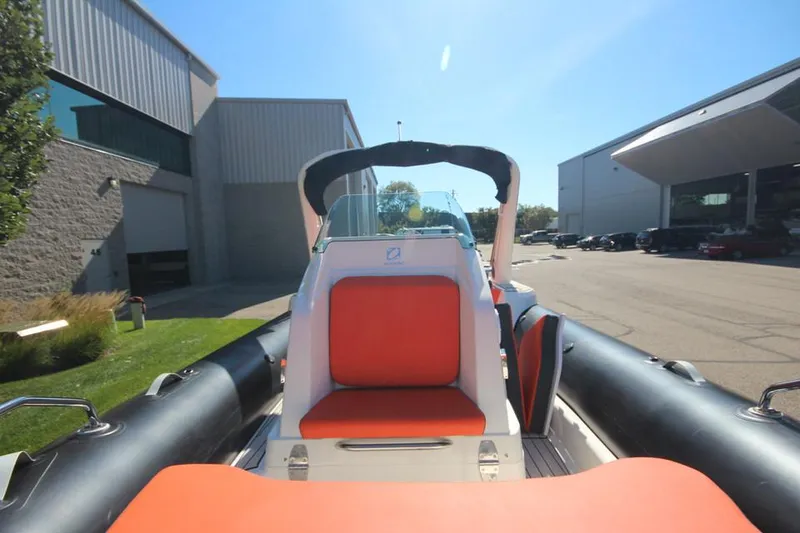 Slide: The Image of 2022 Zodiac Medline 7.5 NEO boat with orange seating, parked outdoors. - 25