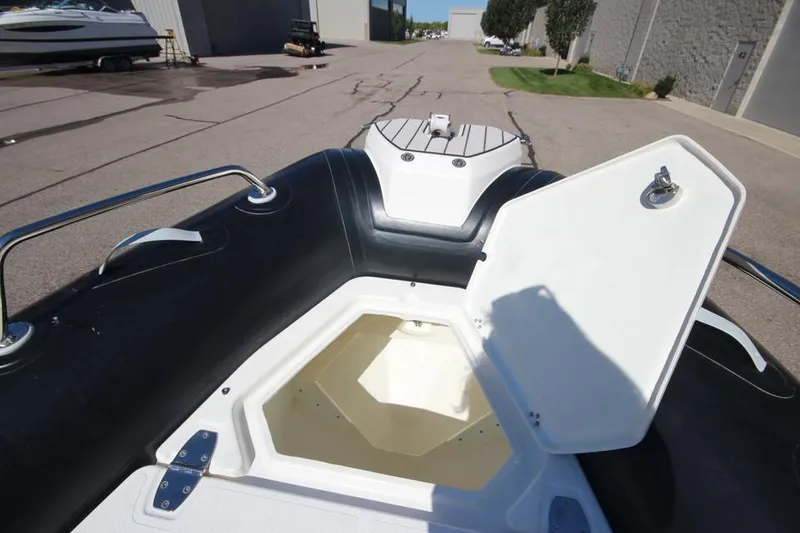 Slide: The Image of 2022 Zodiac Medline 7.5 NEO boat with open storage compartment, docked outdoors. - 28
