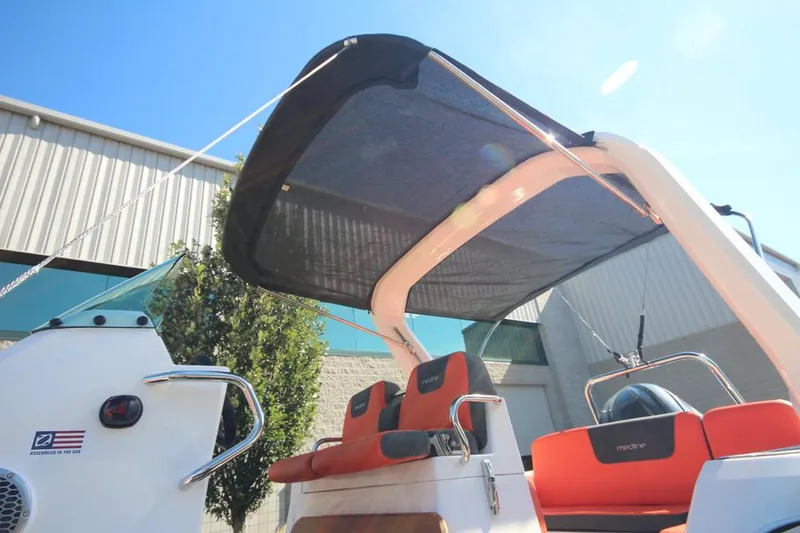 Slide: The Image of 2022 Zodiac Medline 7.5 NEO boat with canopy and orange seating, outdoors. - 32