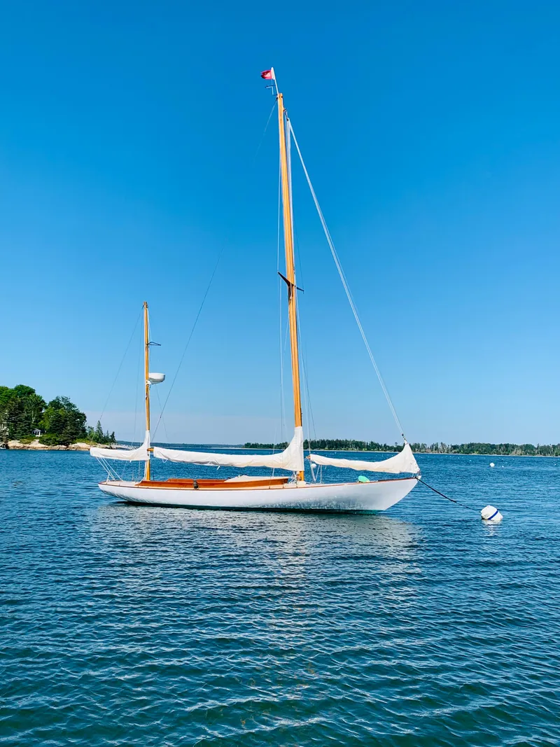 Slide: The Image of Vintage 1914 Buzzards Bay 25 sailboat on calm waters under clear blue sky. - 0