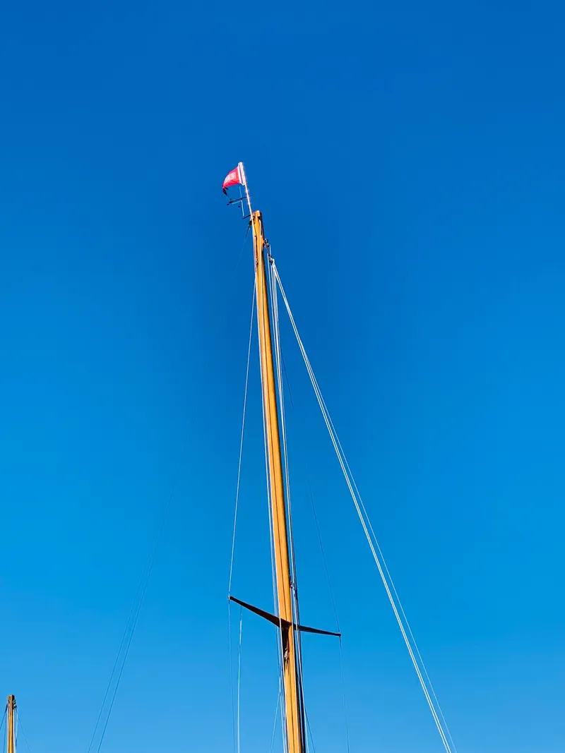 Slide: The Image of Buzzards Bay 25 sailboat mast against clear blue sky, 1914 model. - 16