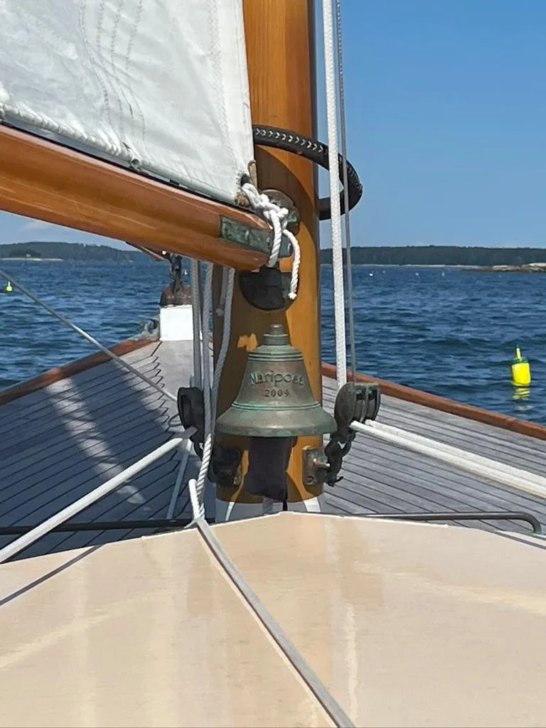Slide: The Image of 1914 Buzzards Bay 25 sailboat with bell, sailing on calm waters. - 20