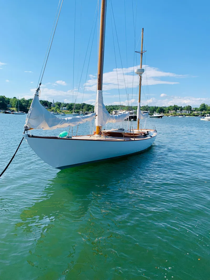 Slide: The Image of Vintage 1914 Buzzards Bay 25 sailboat on calm water. - 4