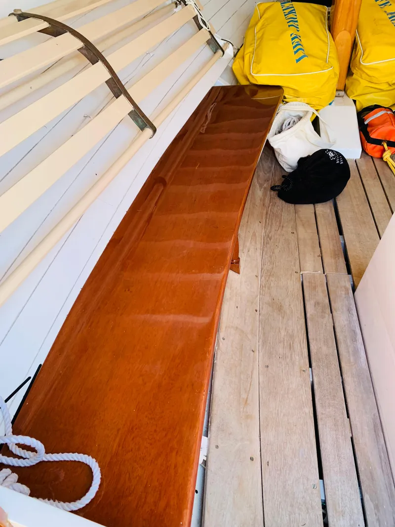 Slide: The Image of Interior of a 1914 Buzzards Bay 25 sailboat with wooden seating and life jackets. - 5