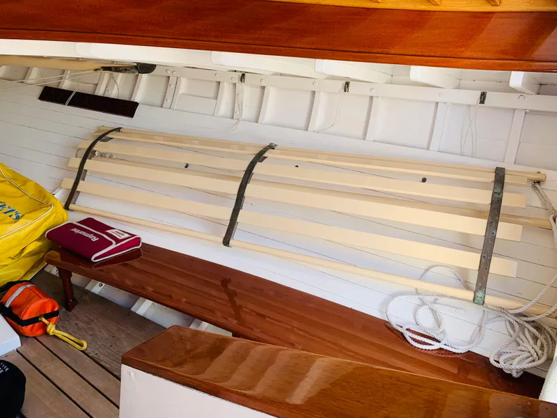 Slide: The Image of Interior of a 1914 Buzzards Bay 25 sailboat with wooden benches and nautical equipment. - 6