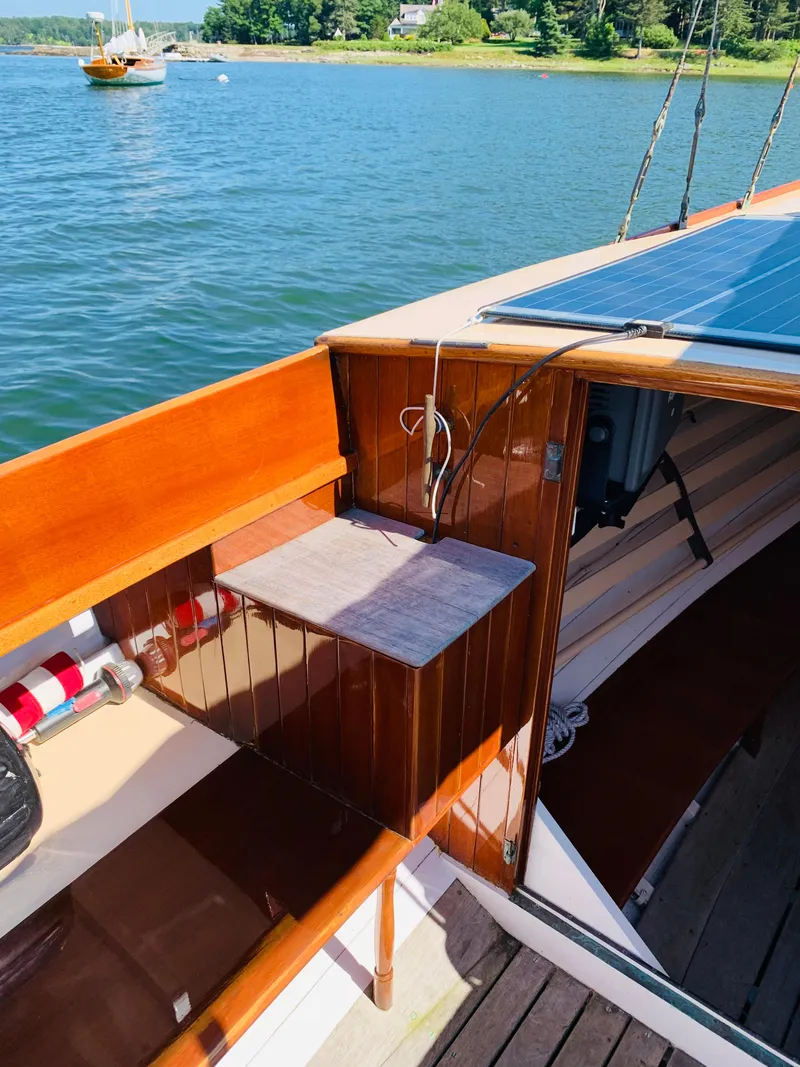 Slide: The Image of Vintage 1914 Buzzards Bay 25 sailboat interior with polished wood finish, docked on a sunny day. - 9