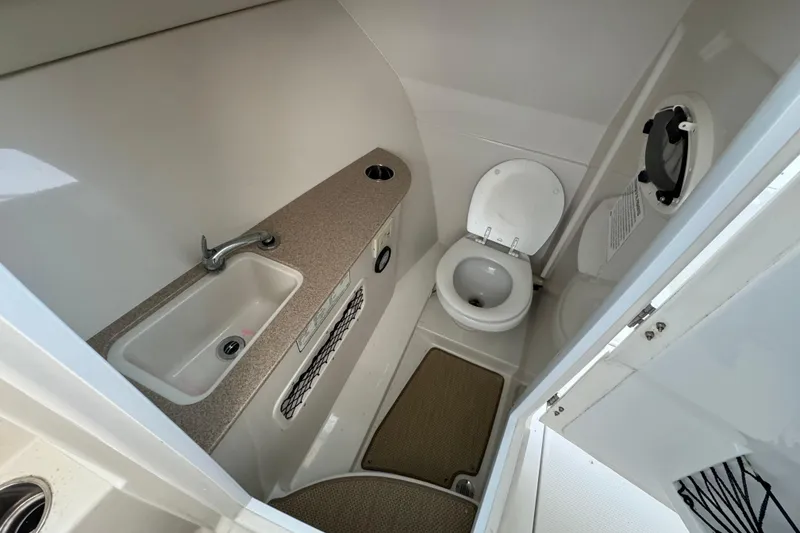 Slide: The Image of 2015 Sailfish 275 DC boat bathroom with sink and toilet. - 12