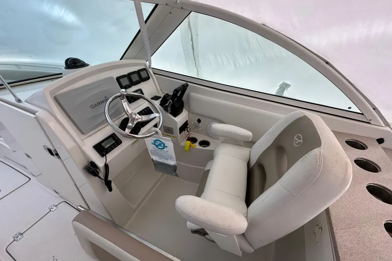 Slide: The Image of 2015 Sailfish 275 DC boat cockpit with steering wheel and Garmin navigation system. - 13
