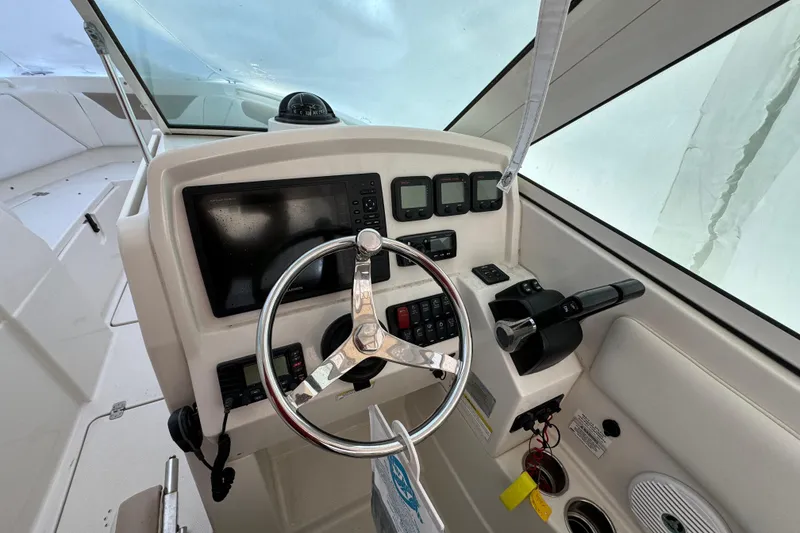 Slide: The Image of Steering console of 2015 Sailfish 275 DC boat with modern controls and navigation equipment. - 14