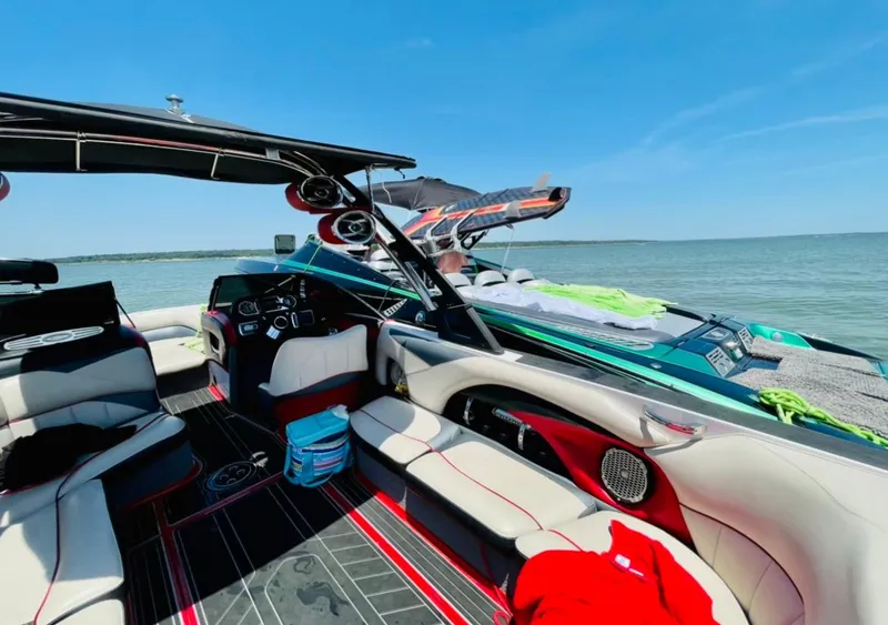 Slide: The Image of 2013 Malibu 247LSV boat interior with wakeboards on a sunny day. - 3