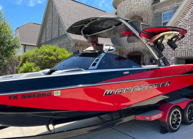 Slide: The Image of 2013 Malibu Wakesetter 247LSV boat in driveway, red and black exterior. - 9