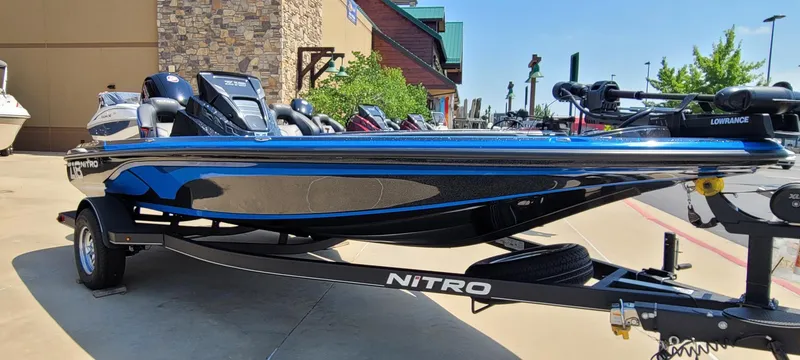 Slide: The Image of 2023 Nitro Z18 boat on a trailer, parked outdoors near a building. - 0
