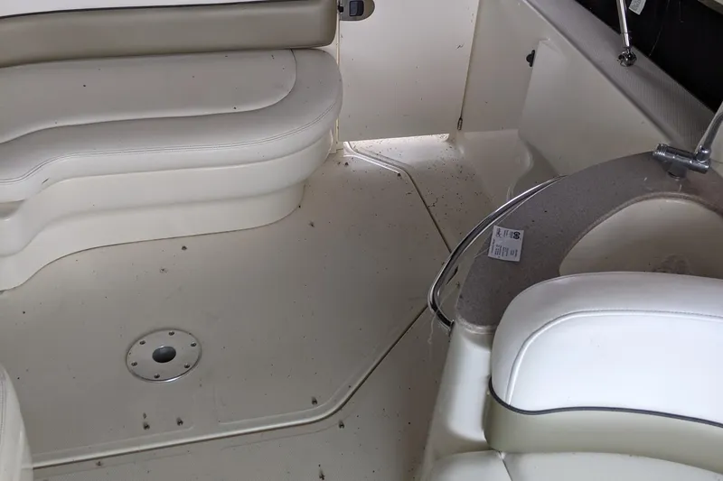 Slide: The Image of 2005 Sea Ray Sundancer 260 interior seating with white upholstery and curved design. - 21