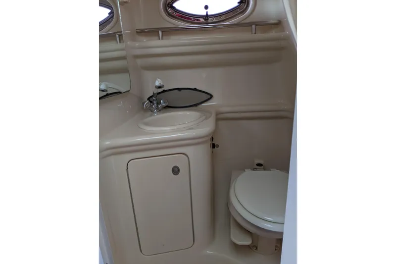 Slide: The Image of 2005 Sea Ray Sundancer 260 bathroom with sink, toilet, and porthole window. - 43